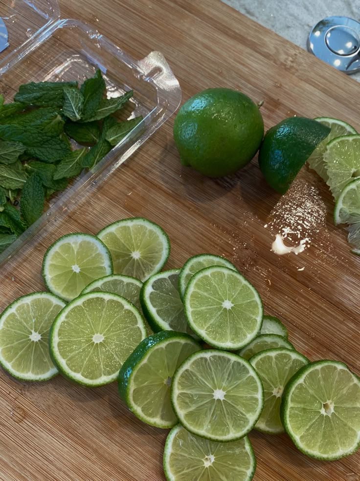 Freshly sliced limes and mint on a wooden board